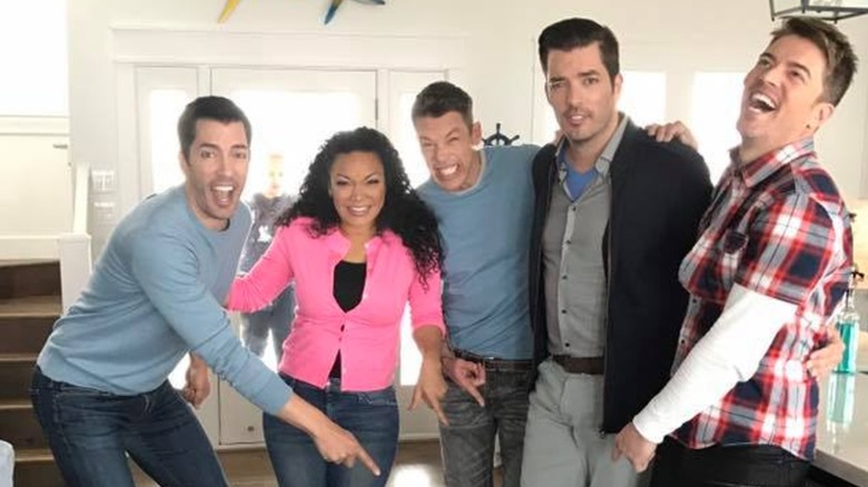 HGTV stars laughing and pointing at a shoe