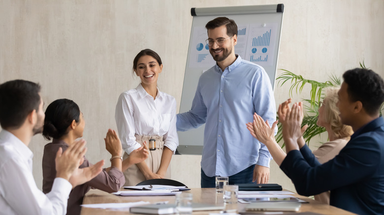 coworkers congratulating woman