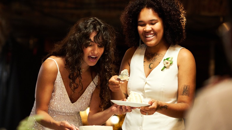 two women cutting wedding cake