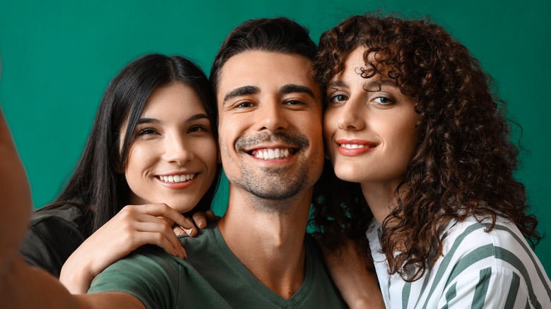 Three people smiling