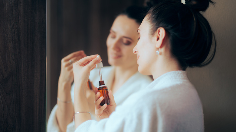 Woman opening bottle of face oil