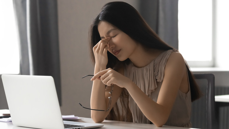 Woman struggling with eyestrain while using the computer