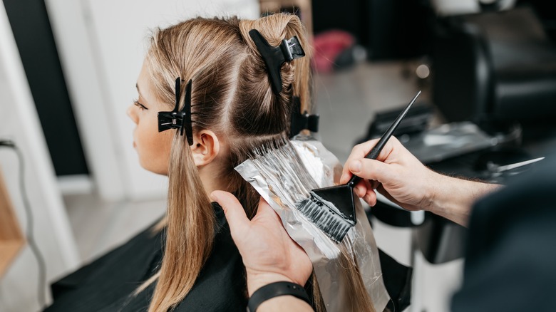 hairdresser dyeing hair with foils