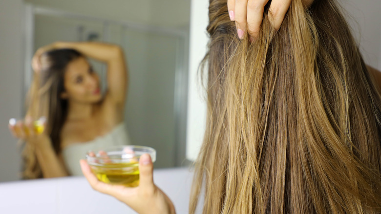 Woman putting oil in hair