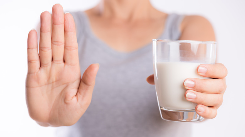 Woman indicating "stop" holding milk