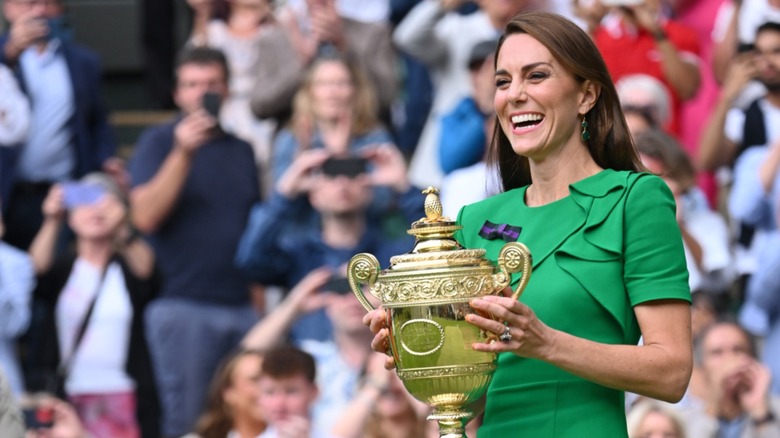 Kate Middleton smiling, holding Wimbledon trophy