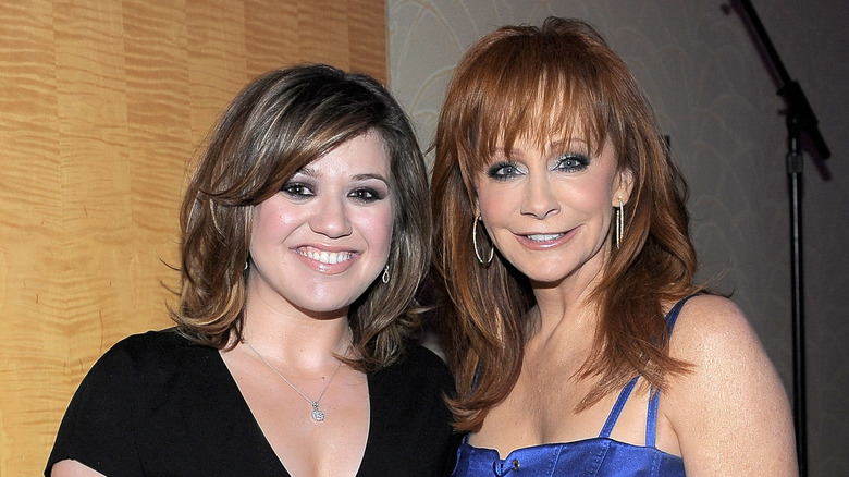 Kelly Clarkson smiles with Reba McEntire.