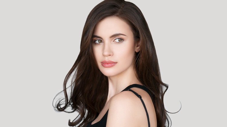 Brunette woman with full lips wearing a black tank top.