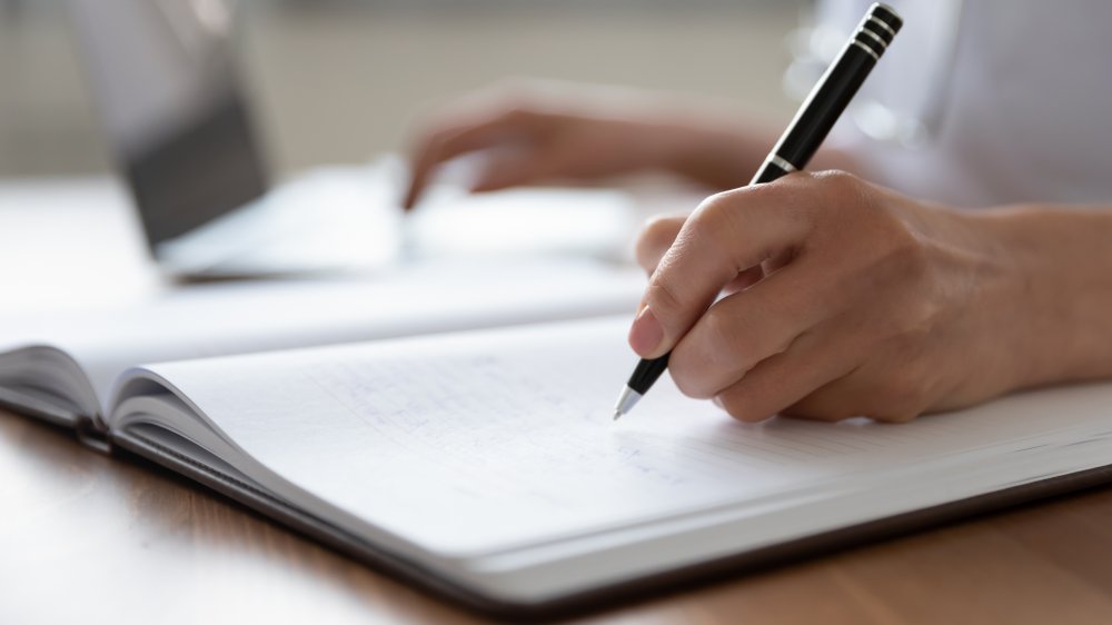 woman's hand making notes with a pen 