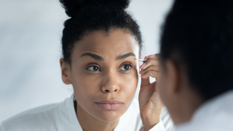 Woman styling eyebrows