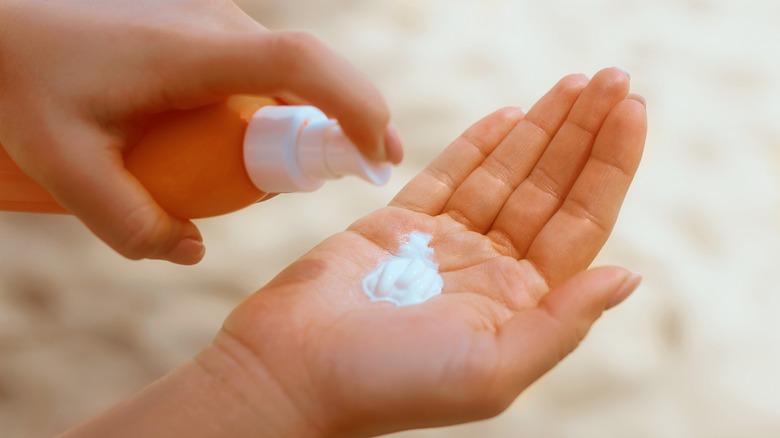 person pumping sunscreen in hand