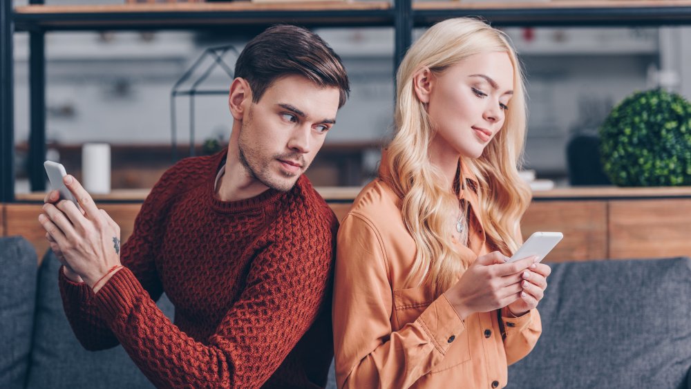 Man looking to see what girlfriend is doing on phone