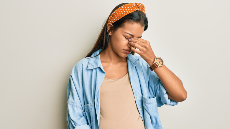 Pregnant woman touching her nose