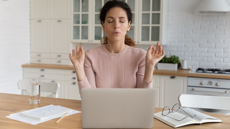 A woman meditating at her desk