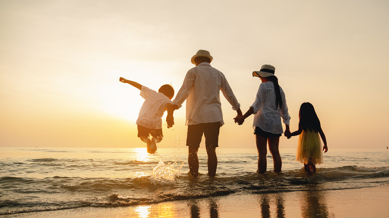 A family holding hands at the ocean 