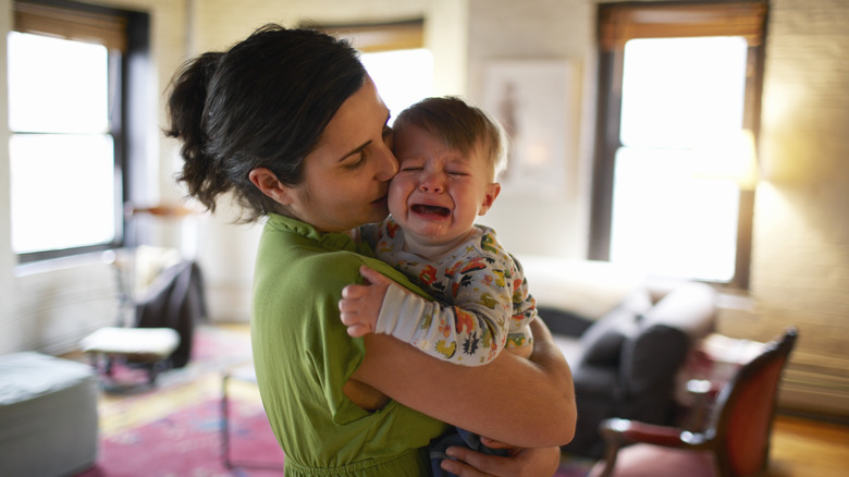 Woman carrying crying baby