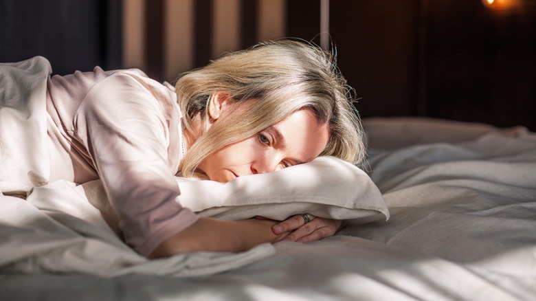 woman restlessly lying in bed