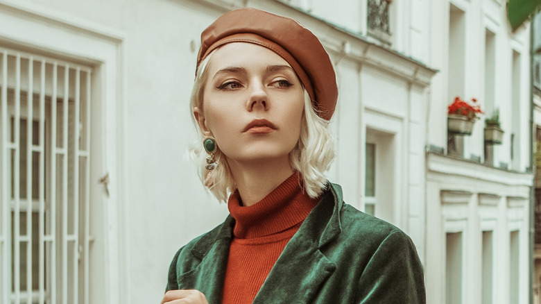 woman wearing a green blazer and beret