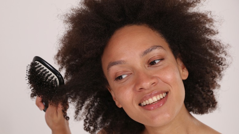 woman brushing out curly hair