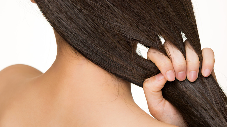 woman running fingers through straight hair