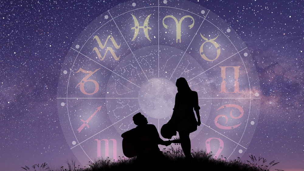 The silhouette of a couple in front of the sky and zodiac symbol 