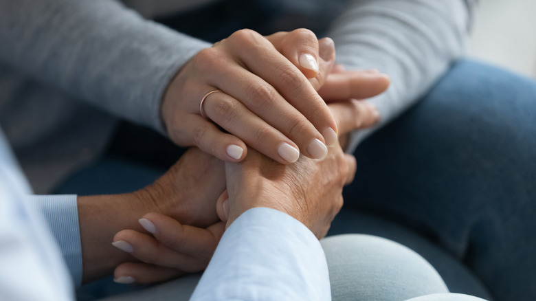 Two women holding hands 