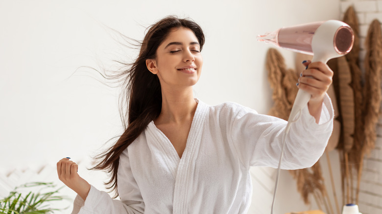 A woman using a hair dryer