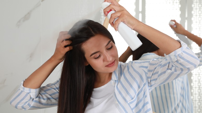 A woman using dry shampoo