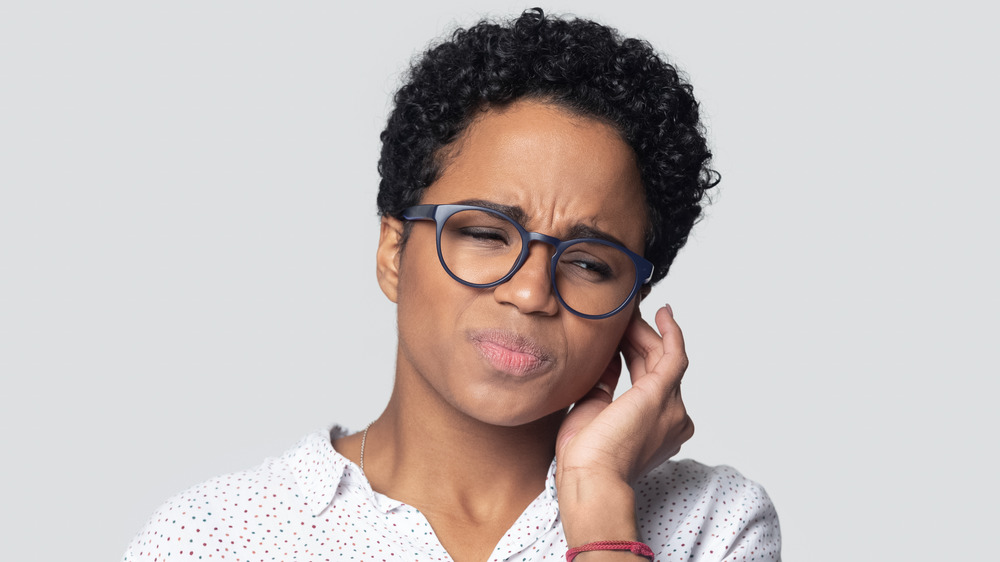 A woman with an itchy ear