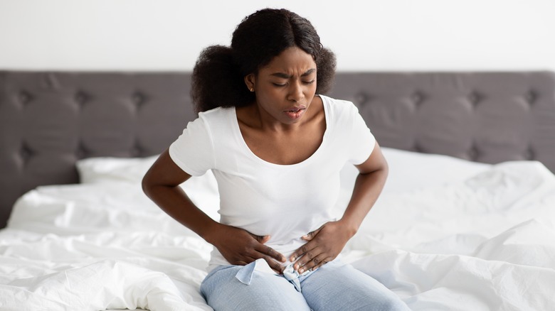 woman holding stomach pain