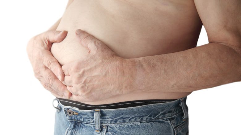 a person clutching their lower stomach area