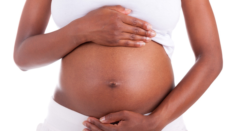 a woman holding her pregnant stomach 