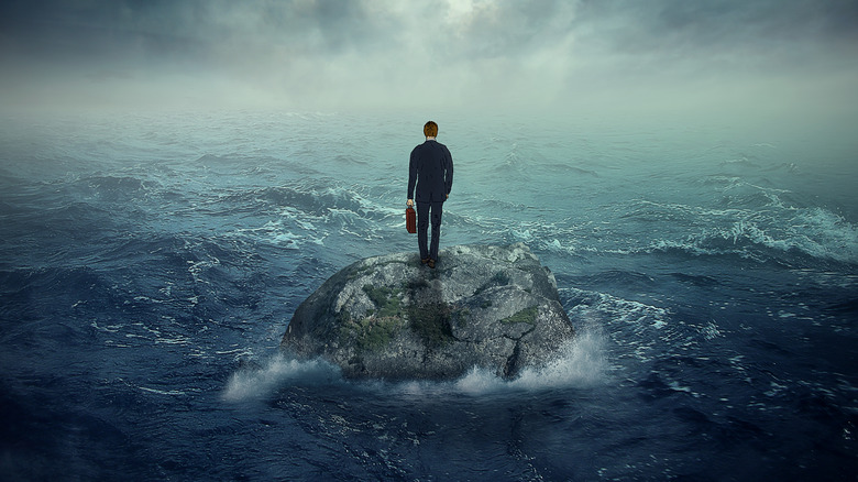 Man on rock in ocean