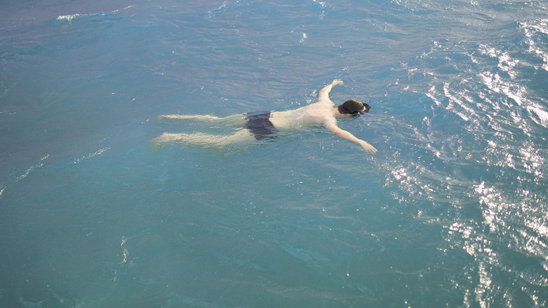 A man floats facedown in water
