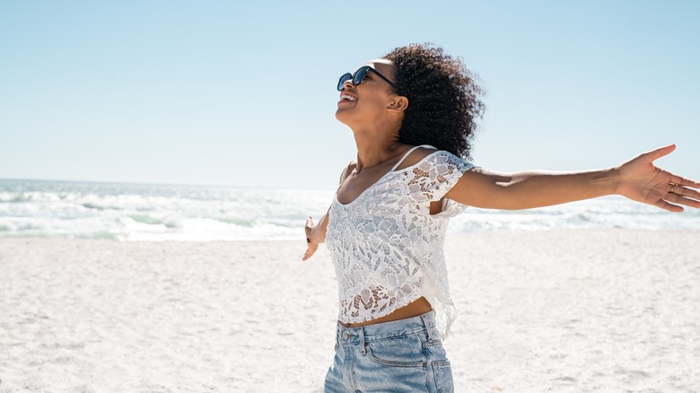 Woman with arms out at the beach 