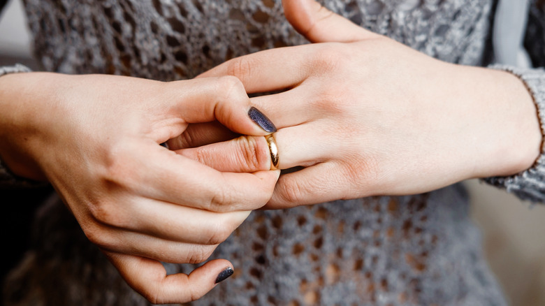 woman taking off wedding ring