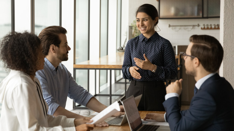 Boss talking to her team in an office setting