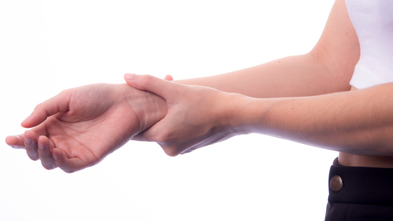 Woman holding her wrist with her hand