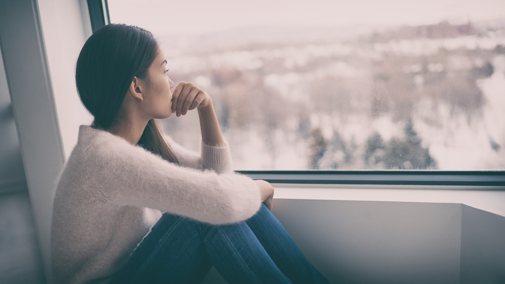 Woman curled up while looking out the window