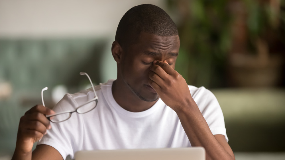 Man with eye strain from being on computer