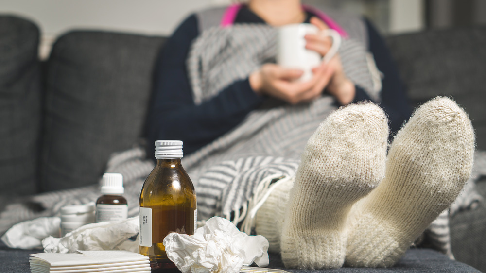 Sick woman sitting on couch