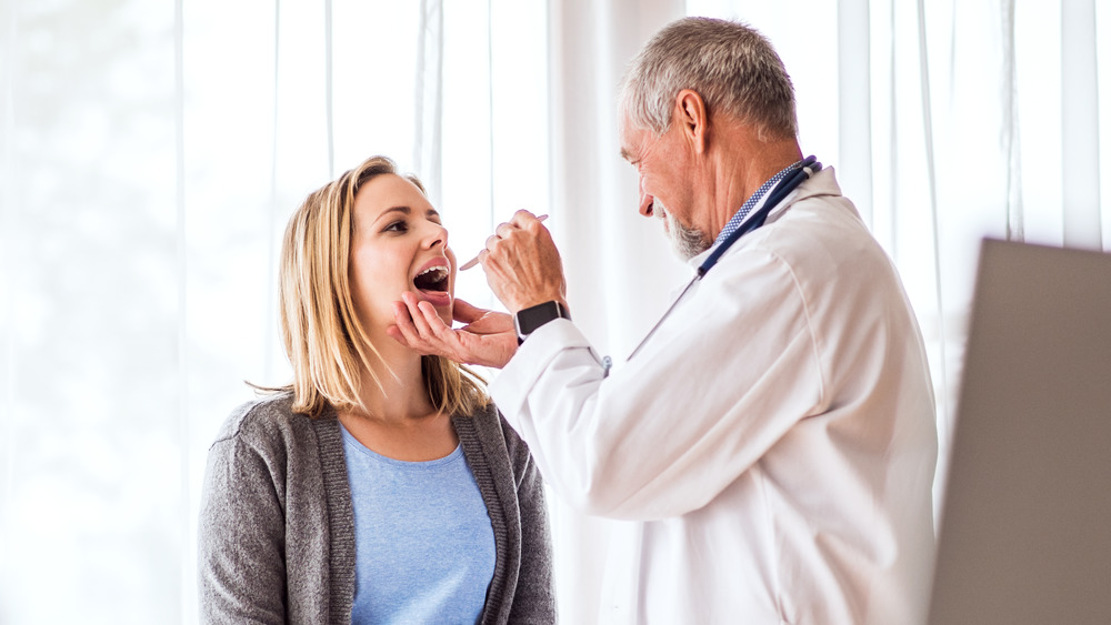 Doctor examining a woman's mouth