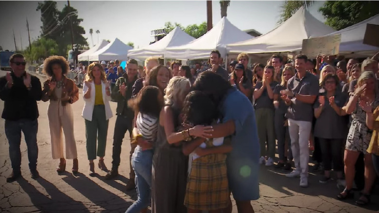 A family embraces at the end of an Extreme Makeover Home Edition episode