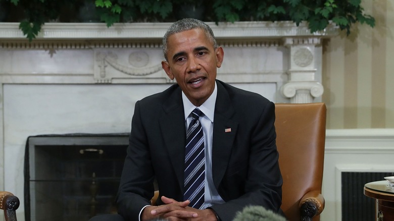 Barack Obama sitting in Oval Office