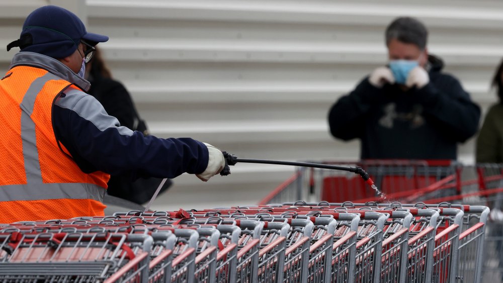 Costco worker disinfecting carts 