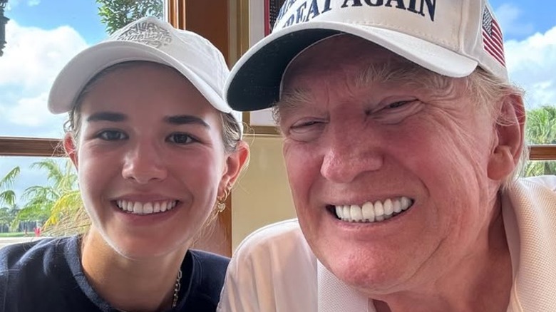 Kai Trump posing with her grandfather Donald Trump