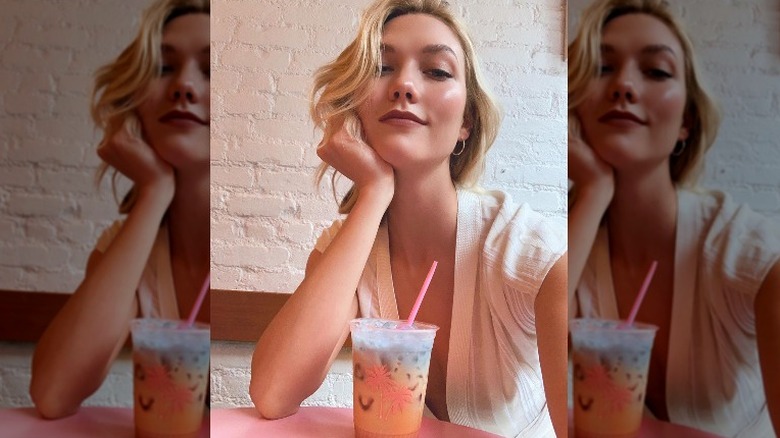 Karlie Kloss with a beverage