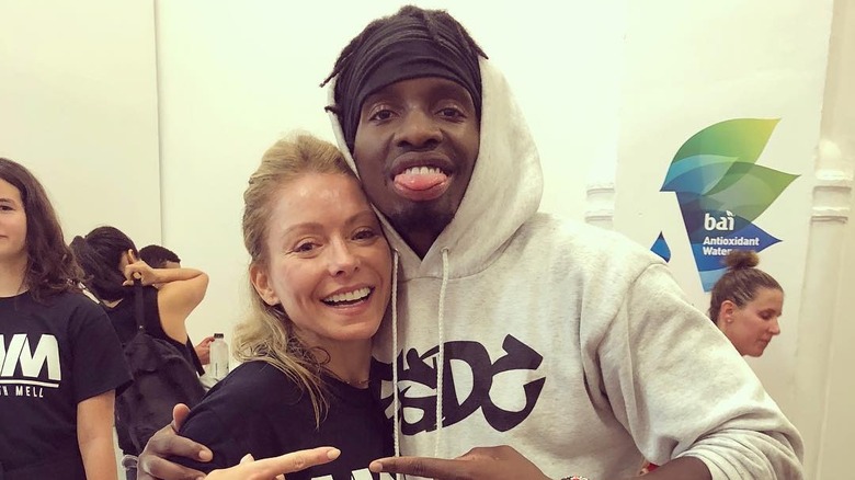 Kelly Ripa smiling with fitness instructor Trammell Logan