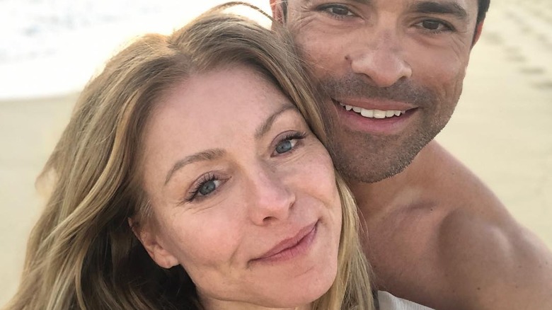 Kelly Ripa smiling with Mark Consuelos on the beach