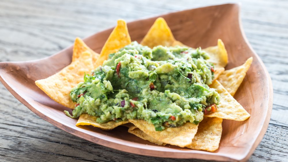 Kendall Jenner typical food: A plate of chips and guac on a wooden table